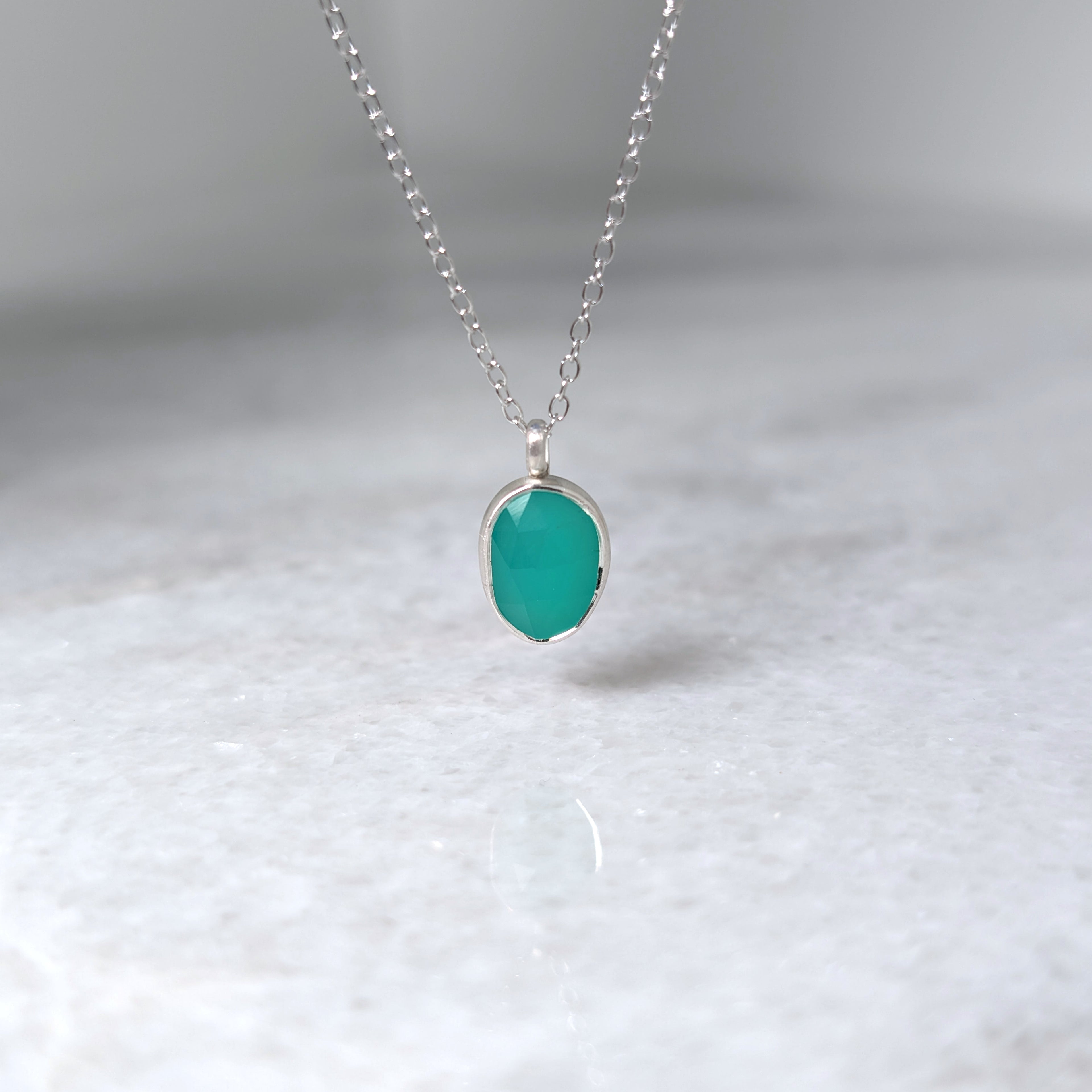 Teal pendant necklace on a white background