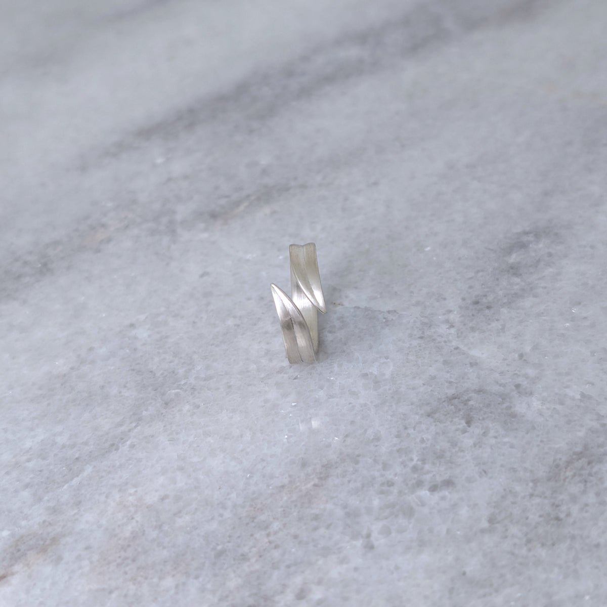Silver leaf blade ring on a marble surface