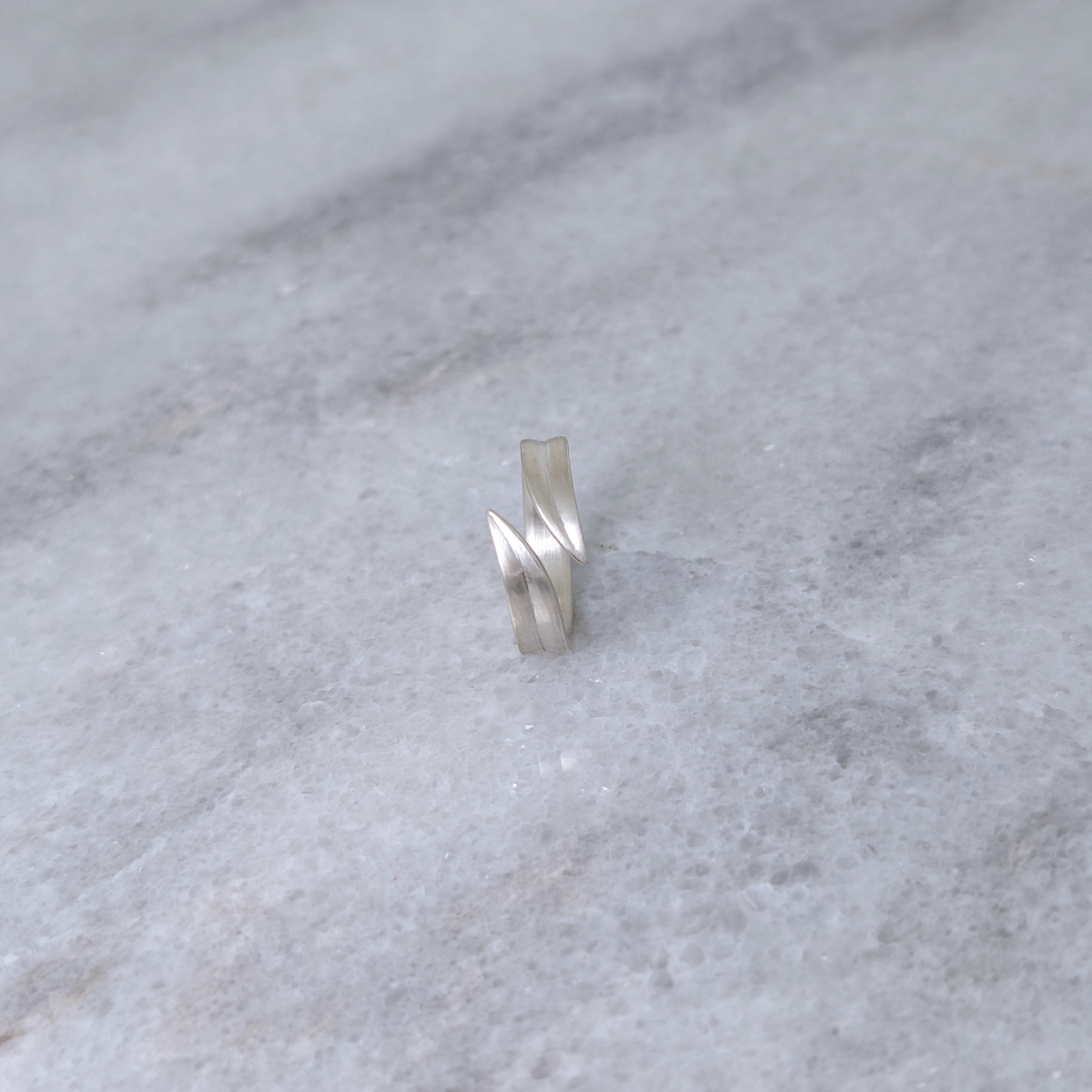 Silver leaf blade ring on a marble surface